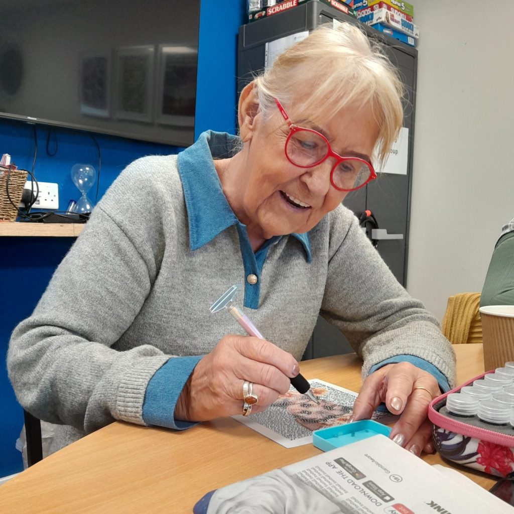 Lady wearing glasses does some diamond painting